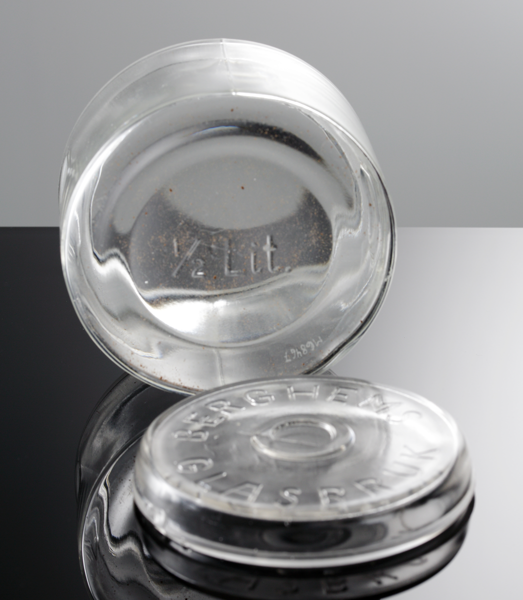 Cylindrisk konserveringsburk, 1/2 liter. Berghems glasbruk. På locket i relief "BERGHEMS GLASBRUK" och i botten på burken "1/2 Ltr".