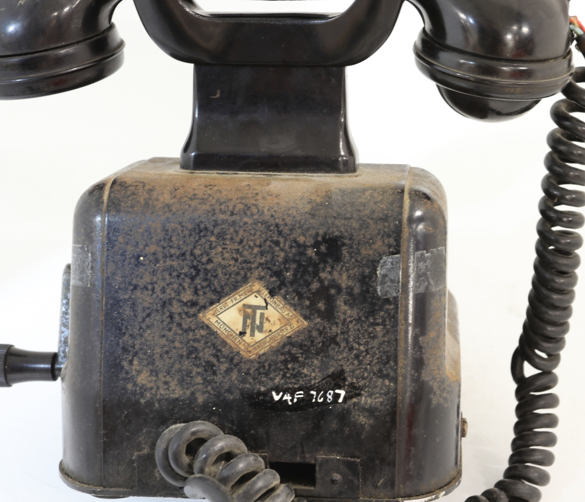 Telefonapparat for manuell sentral, brukt på setesdalsbanen. Apparatet har rektangulær bunn, rette sider, og skrå forkant med flat topp.  Det er en sveiv på siden, og ramme i front med plastdeksel.