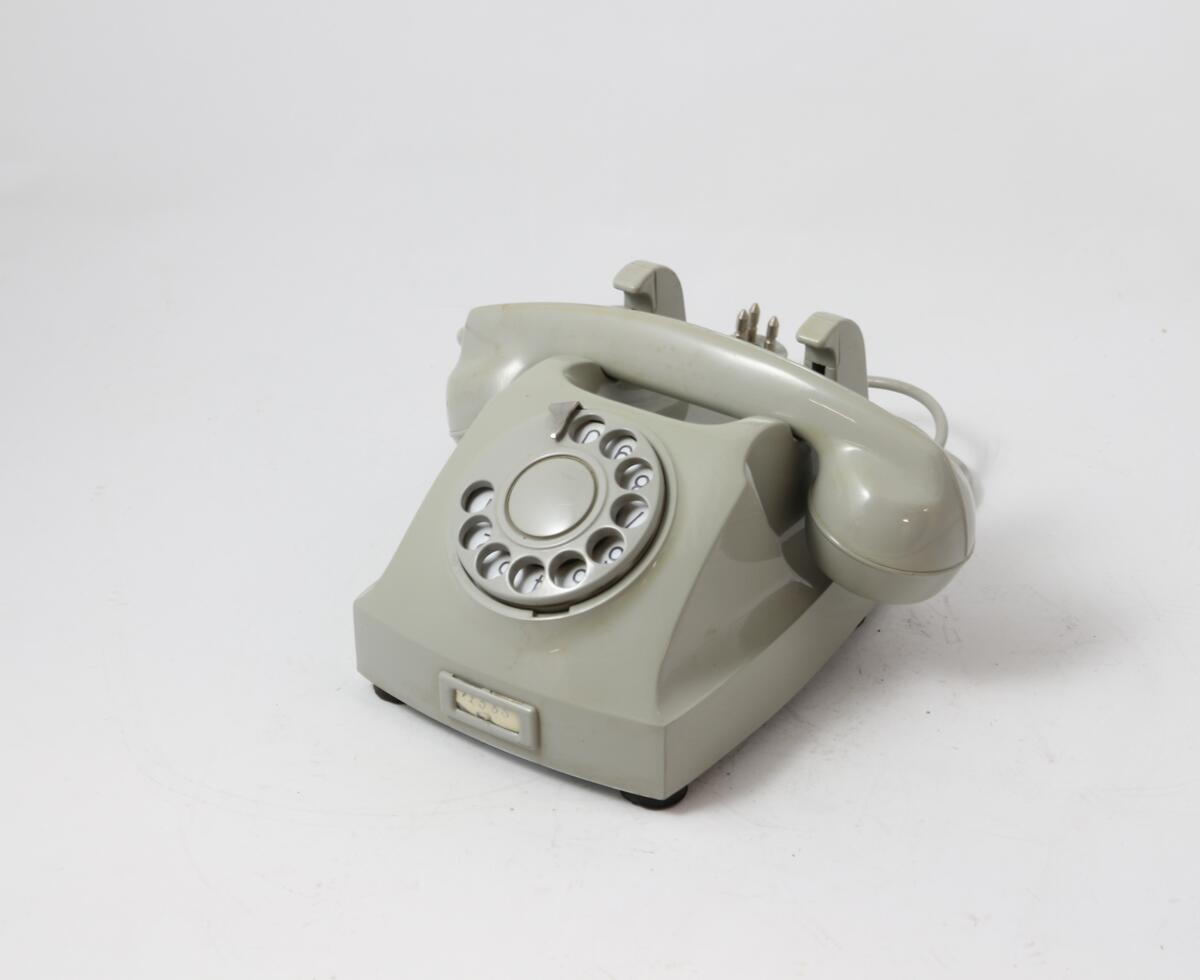 Grå bordtelefon med tallskive