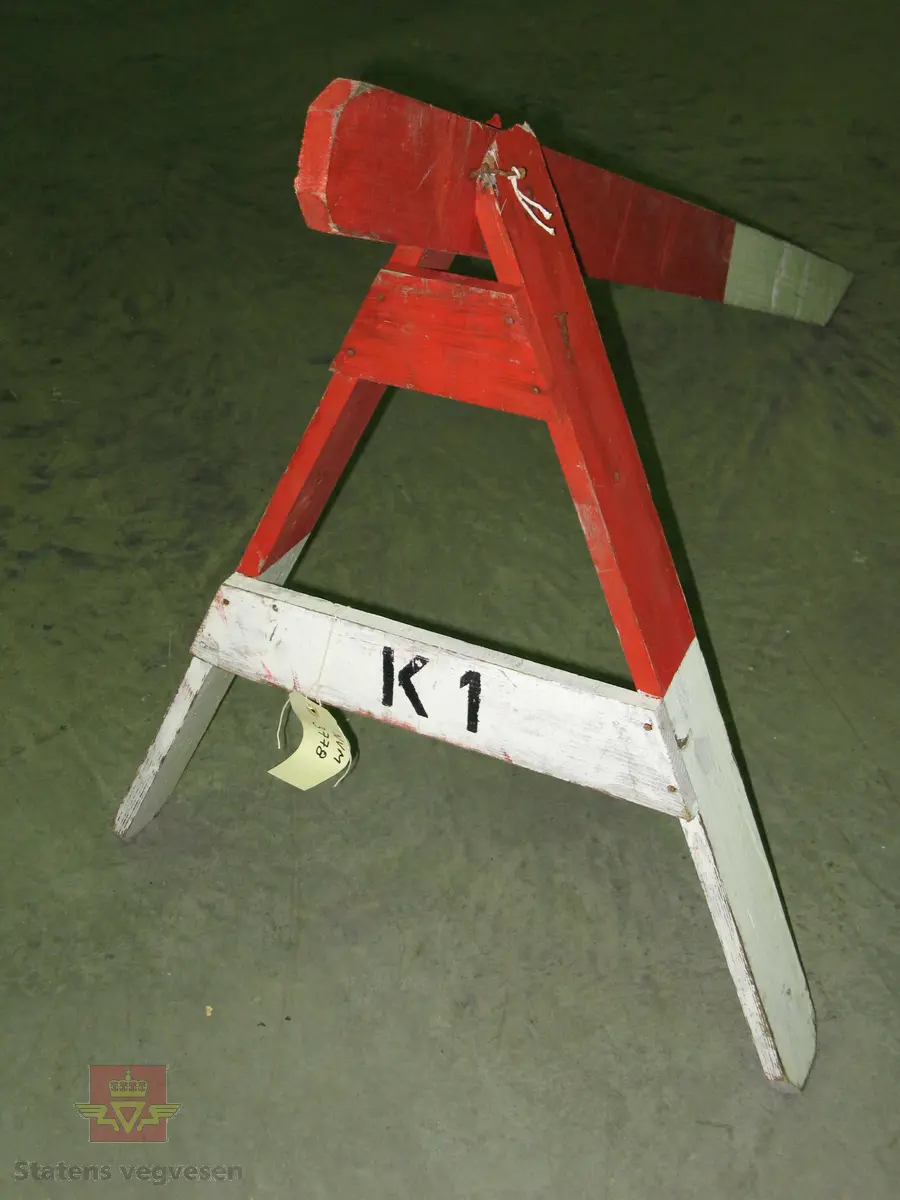 Sperrebukk av tre. Sammenspikret. Malt i røde og hvite felter. Har påskriften K 1.