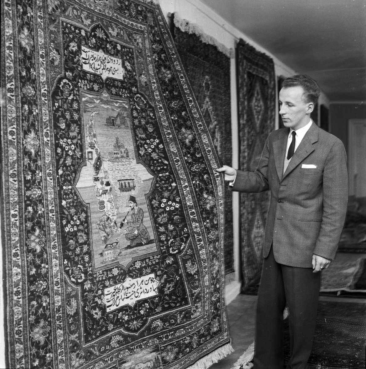 Kjell Lövgren visar upp en tebris-matta på Möbler och Mattor, Uppsala 1958