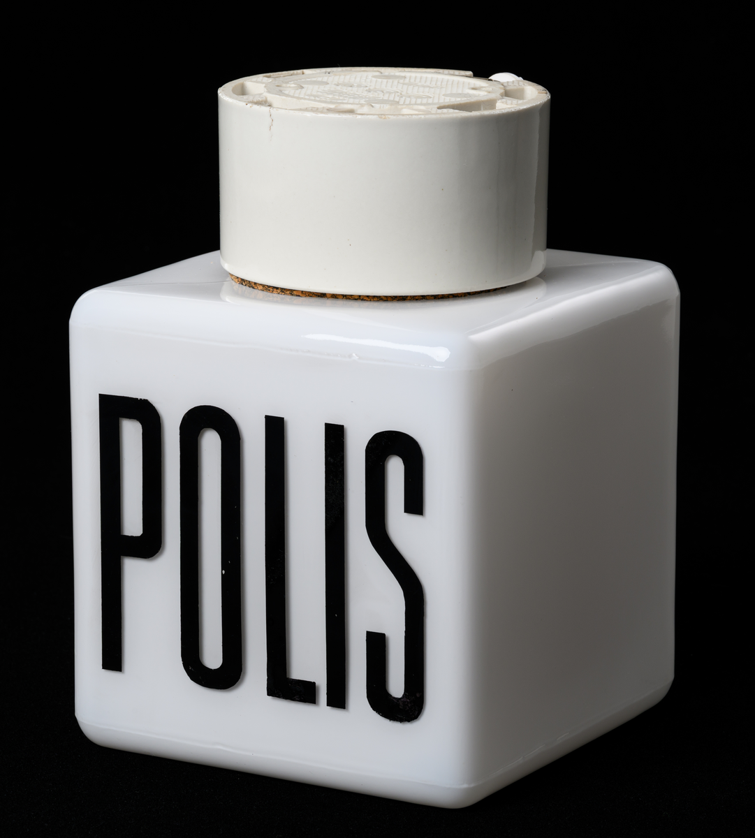 Takarmatur/fasadbelysning. Kubformad opal glaskupa med texten POLIS kupans väggar. Cylindrisk vit porslinssockel.