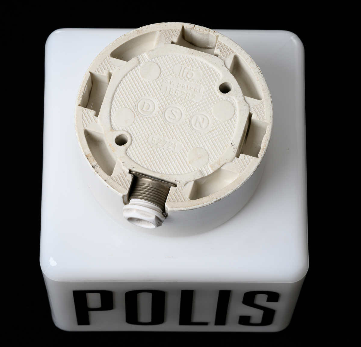 Takarmatur/fasadbelysning. Kubformad opal glaskupa med texten POLIS kupans väggar. Cylindrisk vit porslinssockel.