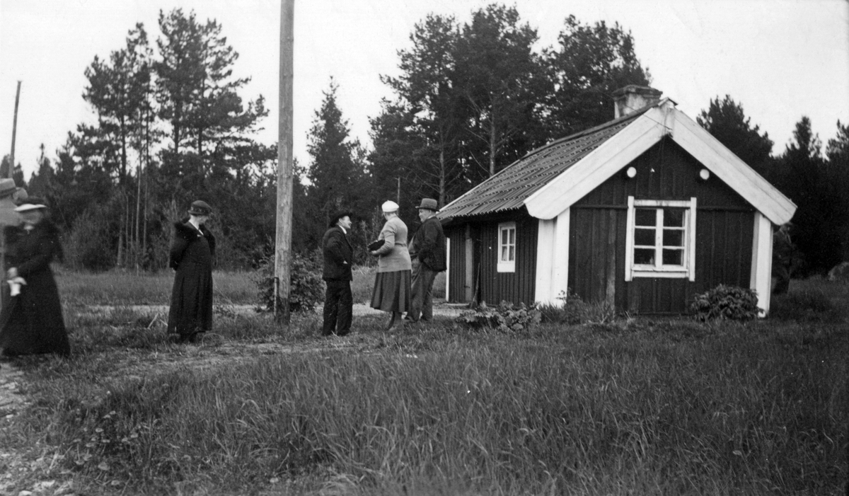 Björkens torp, Gränja. Några personer står framför den lilla stugan. Björkens torp var ett båtsmansställe beläget söder om Hammersta, öster om Gränja by. 

Bebyggelse.

Personer på bilden:
Från vänster: 1. ?, 2. Fru Agrell, 3. Viktor Pettersson, 4. ?, Bagare Agrell.