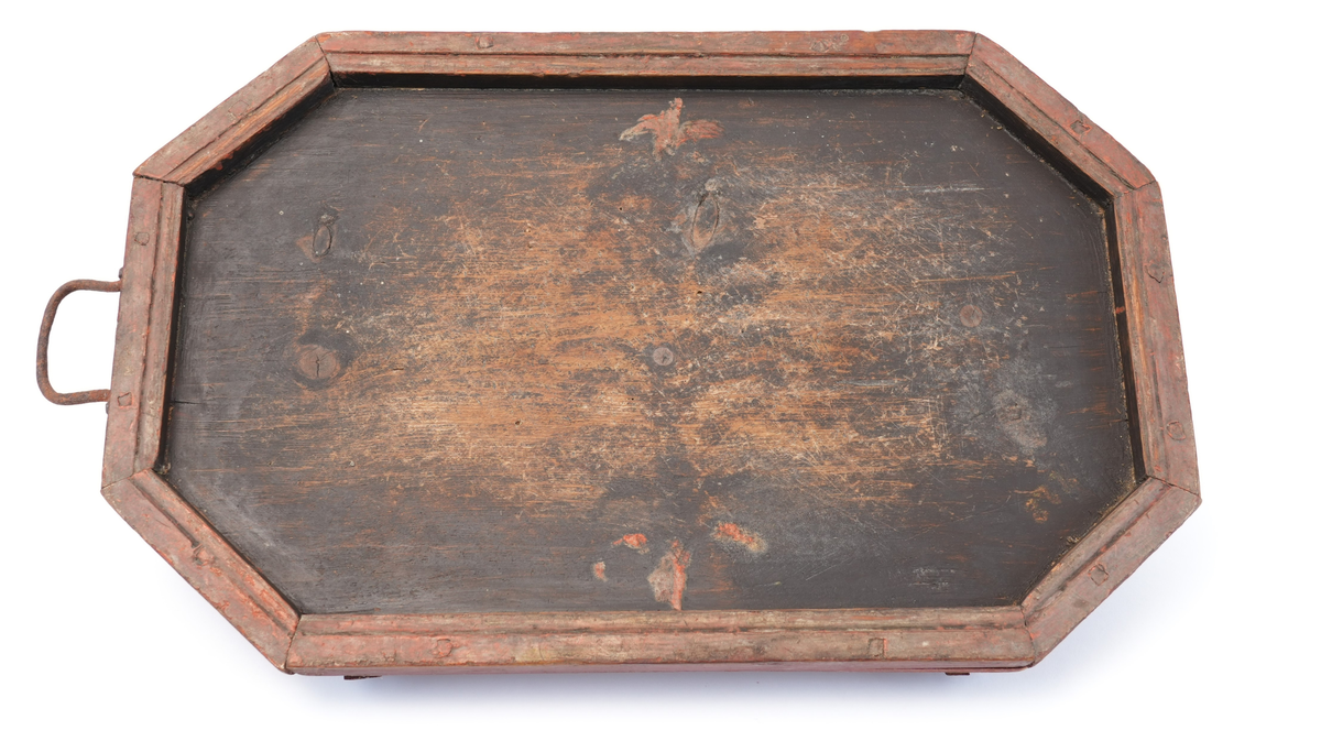Toppen av brettet er måla svart på innsida, med ei raud ramme rundt. Midt på toppen er det spor etter rosemåling (raude blad). Føtene under brettet er utskorne i form av to voluttar som vender mot kvarandre (hjarteform i midten).