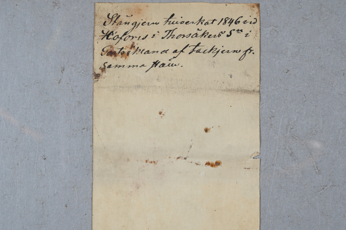 Prov på stångjärn. Märkning på provet med brukets stämpel. Två tillhörande lappar med notering: "Stångjern tillverkat 1846 vid Hofors i Thorsåker Sn i Gestrikland af tackjern från samma ställe."