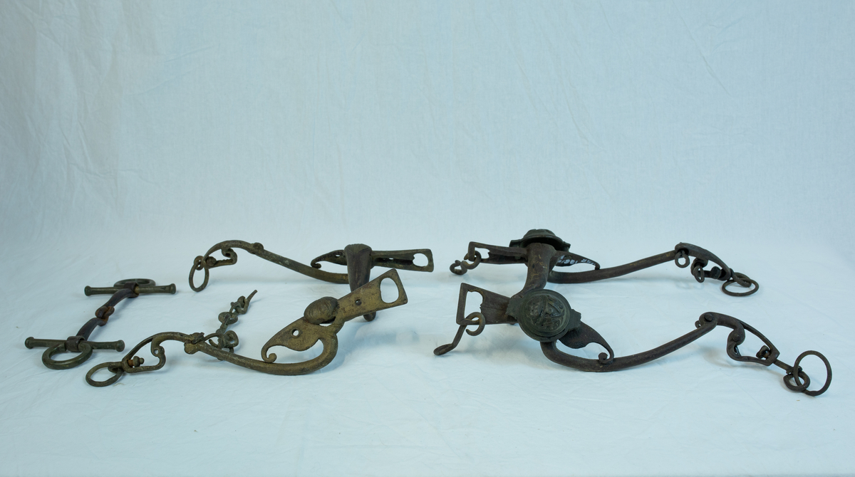 To sett leddet sammen med hyssing. Form: mange ledd er hektet sammen til komplett seletøy b) har boltet inn to "kulekapper" på hver side av hovedleddet. Krone og emblem/ initialer?