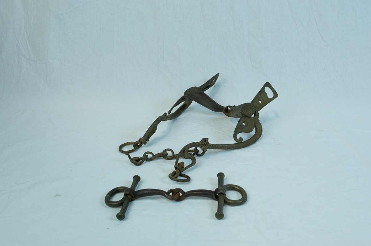 To sett leddet sammen med hyssing. Form: mange ledd er hektet sammen til komplett seletøy b) har boltet inn to "kulekapper" på hver side av hovedleddet. Krone og emblem/ initialer?