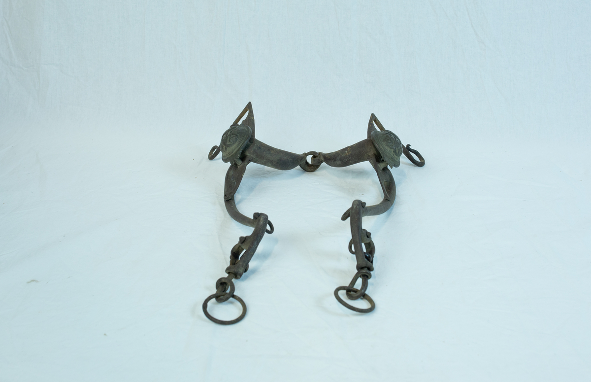 To sett leddet sammen med hyssing. Form: mange ledd er hektet sammen til komplett seletøy b) har boltet inn to "kulekapper" på hver side av hovedleddet. Krone og emblem/ initialer?