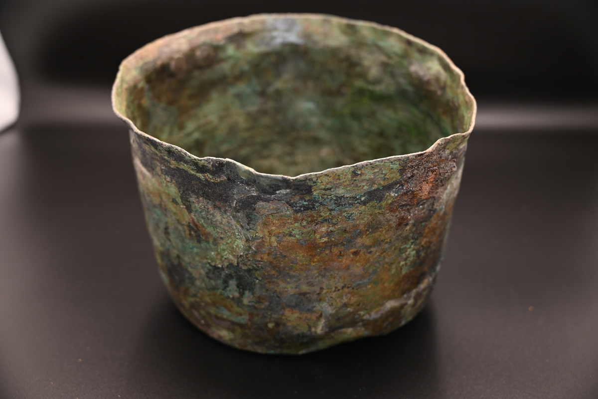 

Kopparkärl innehållandes silverskatt (registrerat i undernummer), Staleskatten.
När kärlet kom till konserveringen låg det kvar i sitt preparat och var omgivet av intorkad hård jord. Det hade tömts på sitt innehåll av lösa silvermynt och övriga föremål. Röntgenbilderna visade att det fanns ett stort antal genomgående sprickor som löpte horisontellt och vertikalt genom kärlets väggar samt i botten. Kärlet var tunt och ömtåligt och till stor del genomkorroderat.  

Kärlets höjd är 16,0 cm, bottendiametern är 18,0 cm och överkantens diameter 23 cm. I kärlet fanns 33 stycken synliga silvermynt fastkorroderade på ytan.

Kärlet är tillverkat av en driven plåt av koppar eller kopparlegering som stomlötts ihop. Botten och ovankant har laskats och lötts fast.

Hankar av järn har nitats fast.