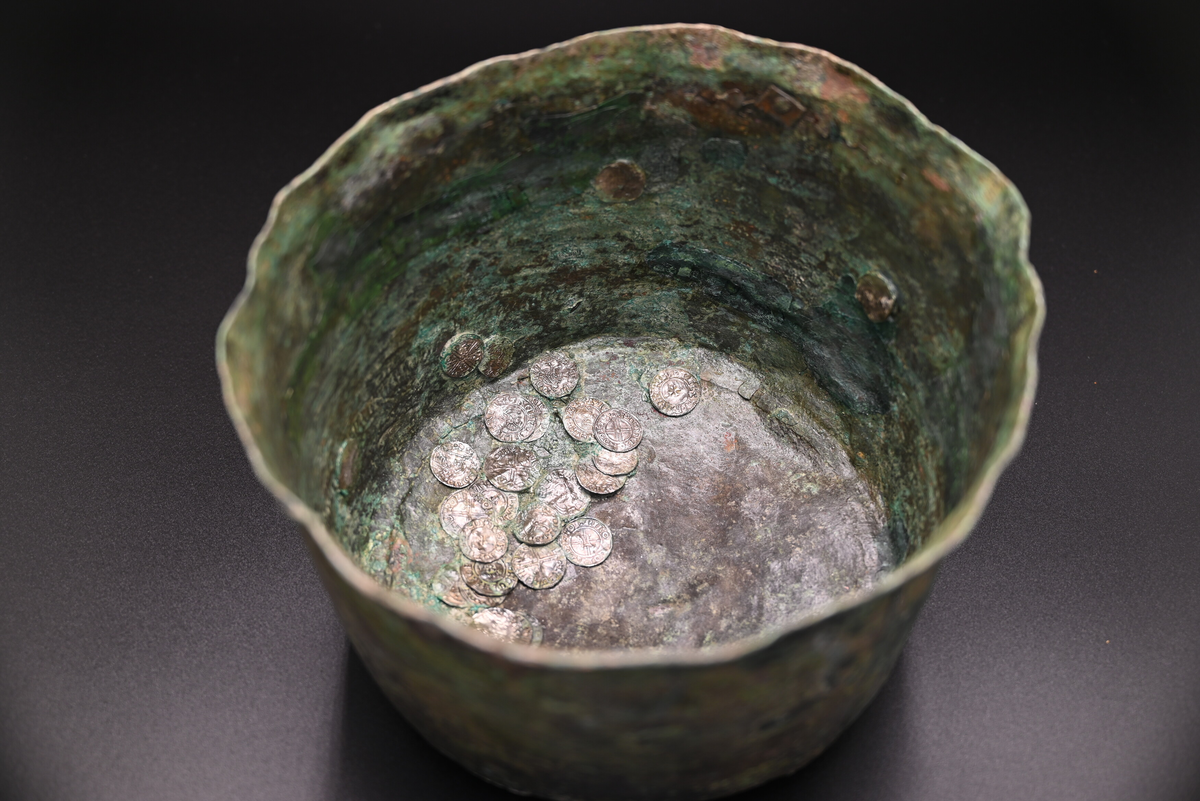 

Kopparkärl innehållandes silverskatt (registrerat i undernummer), Staleskatten.
När kärlet kom till konserveringen låg det kvar i sitt preparat och var omgivet av intorkad hård jord. Det hade tömts på sitt innehåll av lösa silvermynt och övriga föremål. Röntgenbilderna visade att det fanns ett stort antal genomgående sprickor som löpte horisontellt och vertikalt genom kärlets väggar samt i botten. Kärlet var tunt och ömtåligt och till stor del genomkorroderat.  

Kärlets höjd är 16,0 cm, bottendiametern är 18,0 cm och överkantens diameter 23 cm. I kärlet fanns 33 stycken synliga silvermynt fastkorroderade på ytan.

Kärlet är tillverkat av en driven plåt av koppar eller kopparlegering som stomlötts ihop. Botten och ovankant har laskats och lötts fast.

Hankar av järn har nitats fast.