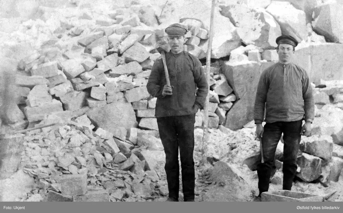 Portrett av stenhugger/steinhoggere, ant. i Halden. Gustav Vilhelm Holmberg. f. 1891 i Skalltorp, Sverige til venstre. Gustav fikk sin første jobb i Norge som steinhogger. Han ble gift med Anna Terese Karlson f. 1896 i Sverige som kom over til Norge seinere. Gustav fikk seinere jobb på Borregaard og arbeidet der til han  døde. Den andre personene er ukjent.