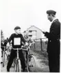 Poliskonstapel  Lennart Baugert har trafikundervisning med några skolpojkar. Alvesta 1956.