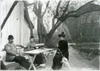 Västerås, kv. Oden.
Tre personer sitter i Öjermarks trädgård. C:a 1900-1910.