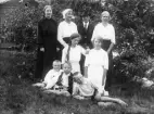 Personerna är stående från vänster: Stina Nilsson född 1896, Linnéa Lagerkvist, Petrus Nilsson född 1900, okänd kvinna. Knästående från vänster: Signe Lagerkvist och Märta Nilsson, född 1903. I gräset till vänster Bror Nilsson född 1906, samt två barn till Lagerkvist.