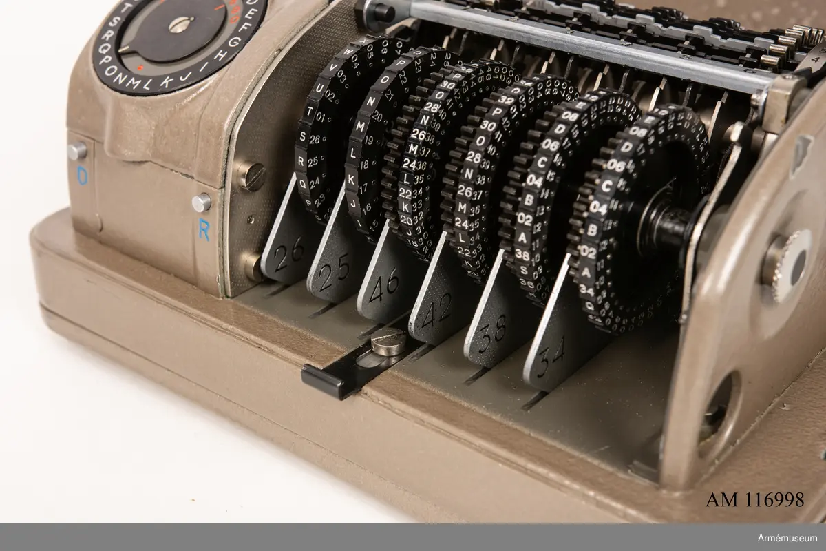 Med nycklar.

Text på liten bricka på högra sidan: "Type CX-52 No 10924, Manufactured for Crypto AG Zug Switzerland by AB Cryptoteknik Stockholm Sweden".

Under krypteringsapparatens lock finns en liten vit lapp märkt "MV Boden Avd 4 Översyn 11 68", dvs troligen Miloverkstaden Boden, november 1968. 

De fysiska nycklarna ger olika access till användarna. Den nyckel med ett hack i ovansidan på nyckeln öppnar endast yttre luckan och dras sedan ut. Därpå förs nyckeln med två hack på nyckelörat in vilket gör att inre luckan går att öppna. Den senare nyckeln ger access till själva innandömet och rotorhjulen går att ta ut efter att sprinten på högra sidan dragits ut.