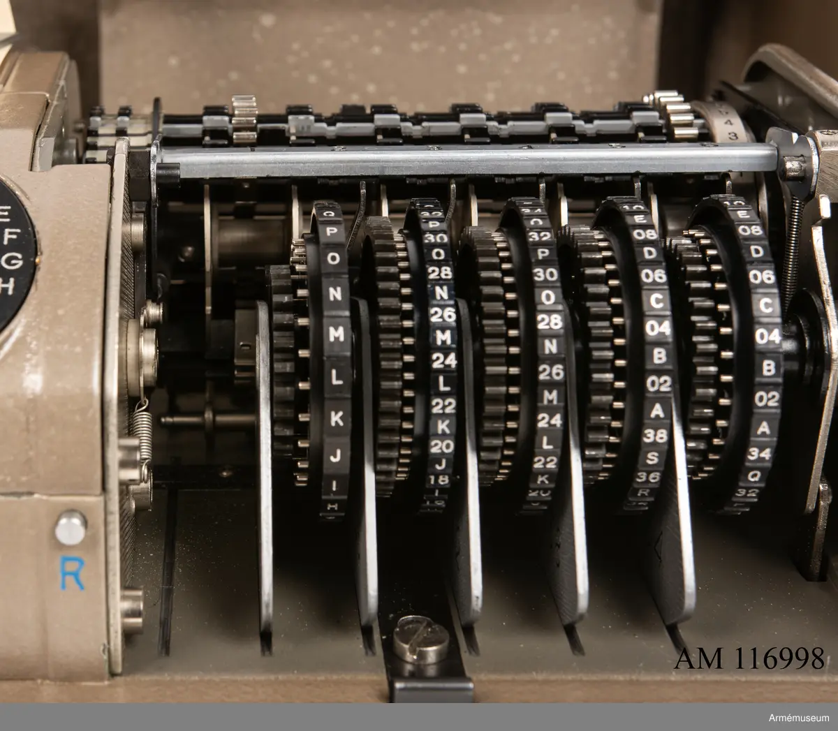 Med nycklar.

Text på liten bricka på högra sidan: "Type CX-52 No 10924, Manufactured for Crypto AG Zug Switzerland by AB Cryptoteknik Stockholm Sweden".

Under krypteringsapparatens lock finns en liten vit lapp märkt "MV Boden Avd 4 Översyn 11 68", dvs troligen Miloverkstaden Boden, november 1968. 

De fysiska nycklarna ger olika access till användarna. Den nyckel med ett hack i ovansidan på nyckeln öppnar endast yttre luckan och dras sedan ut. Därpå förs nyckeln med två hack på nyckelörat in vilket gör att inre luckan går att öppna. Den senare nyckeln ger access till själva innandömet och rotorhjulen går att ta ut efter att sprinten på högra sidan dragits ut.