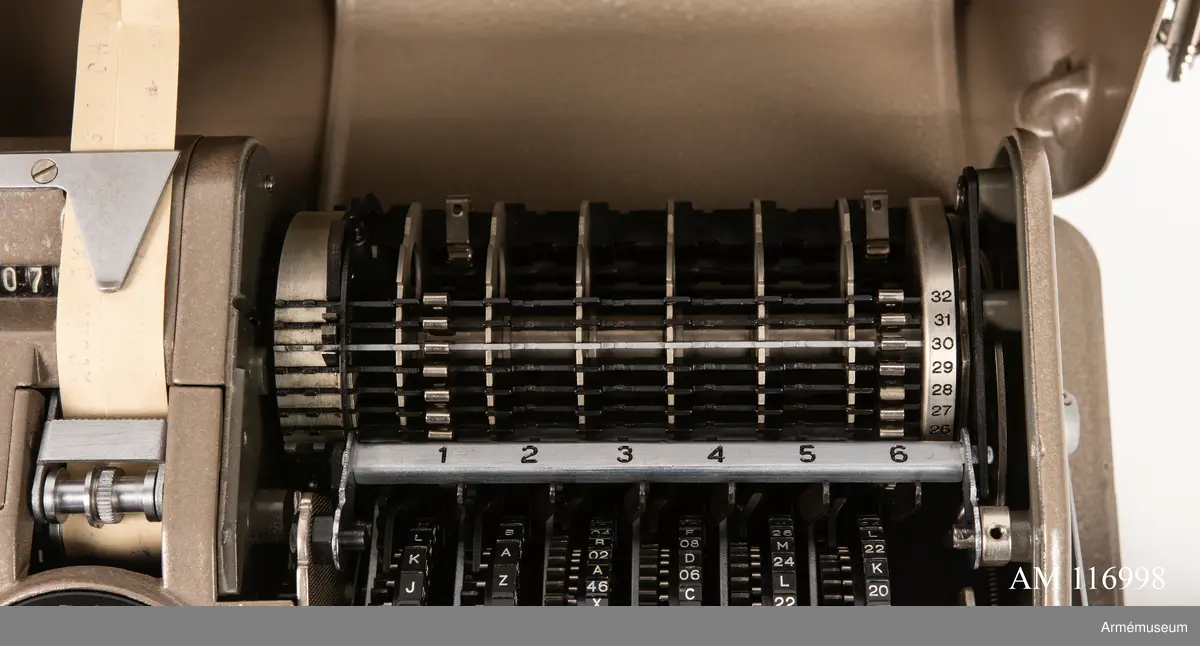 Med nycklar.

Text på liten bricka på högra sidan: "Type CX-52 No 10924, Manufactured for Crypto AG Zug Switzerland by AB Cryptoteknik Stockholm Sweden".

Under krypteringsapparatens lock finns en liten vit lapp märkt "MV Boden Avd 4 Översyn 11 68", dvs troligen Miloverkstaden Boden, november 1968. 

De fysiska nycklarna ger olika access till användarna. Den nyckel med ett hack i ovansidan på nyckeln öppnar endast yttre luckan och dras sedan ut. Därpå förs nyckeln med två hack på nyckelörat in vilket gör att inre luckan går att öppna. Den senare nyckeln ger access till själva innandömet och rotorhjulen går att ta ut efter att sprinten på högra sidan dragits ut.