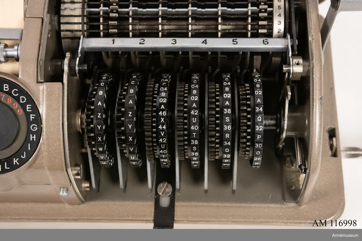 Med nycklar.

Text på liten bricka på högra sidan: "Type CX-52 No 10924, Manufactured for Crypto AG Zug Switzerland by AB Cryptoteknik Stockholm Sweden".

Under krypteringsapparatens lock finns en liten vit lapp märkt "MV Boden Avd 4 Översyn 11 68", dvs troligen Miloverkstaden Boden, november 1968. 

De fysiska nycklarna ger olika access till användarna. Den nyckel med ett hack i ovansidan på nyckeln öppnar endast yttre luckan och dras sedan ut. Därpå förs nyckeln med två hack på nyckelörat in vilket gör att inre luckan går att öppna. Den senare nyckeln ger access till själva innandömet och rotorhjulen går att ta ut efter att sprinten på högra sidan dragits ut.