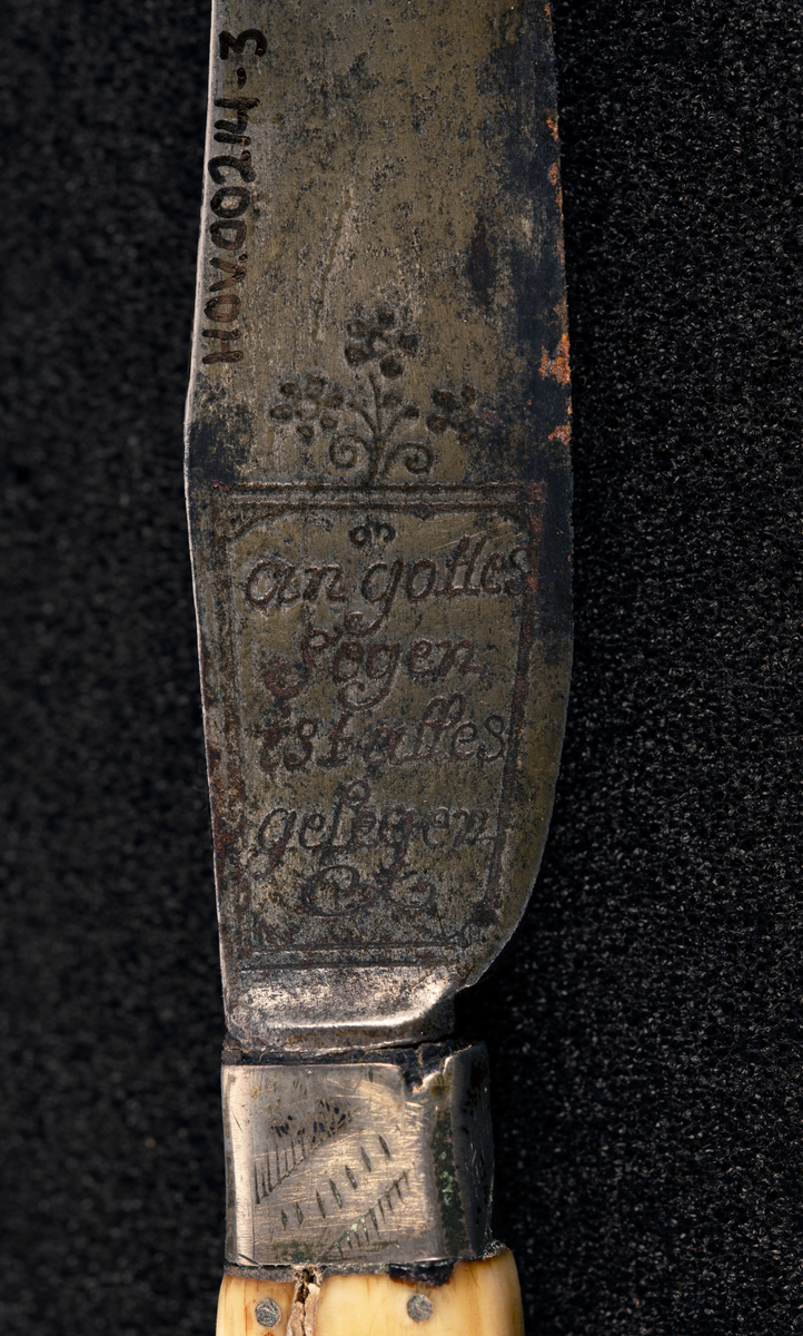 Kniv med beinskaft med metallpryd, blad med inskripsjoner.