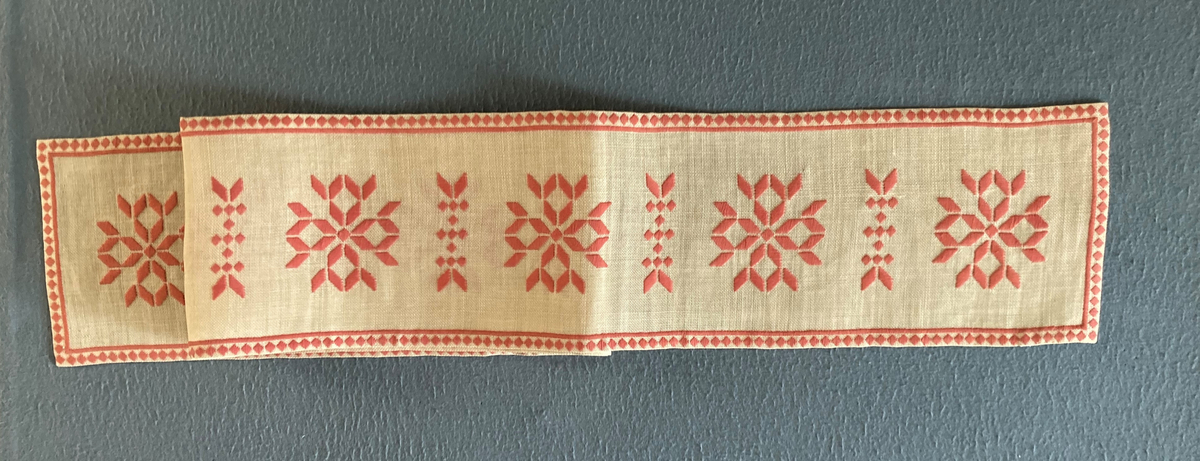 YMHF-01:1. Duk/remsa broderad på halvblekt värmlandslinne i plattsöm med rosa bomullsgarn  24/2, färgnr 83. 
Även märkt B1    
 
YMHF-01:2 Duk/remsa storlek 757x165 mm. Broderad i blått på vitt linne. Halvfållad  

Mönstret är omarbetat av Britta Rendahl efter ett praktörngott från Njurunda. 

 

