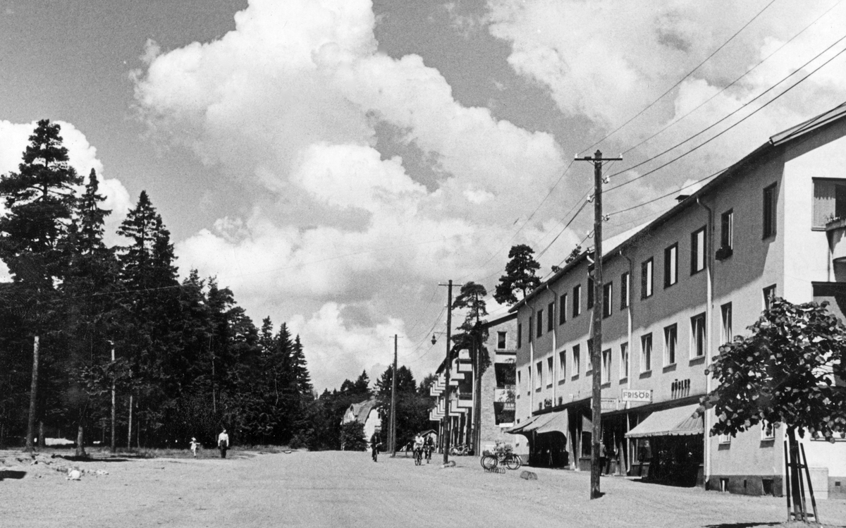 Nynäsvägen i höjd med nummer 26 och 24. Kvarteren Lejonet och Merkurius. Till vänster syns det område som i dag är Stadsparken. 

Bebyggelse, sommar.