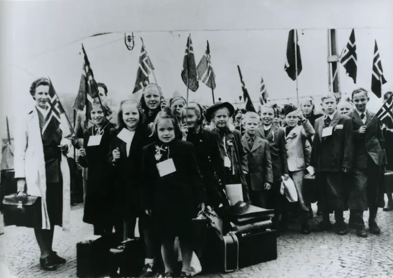 Bergen jernbanestasjon 1945. Borna kjem heim frå opphald i Sverige. Kvinna på fotoet er frå Nasjonalhjelpen.