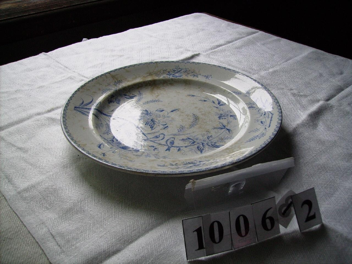Flintporslin fån Gustavsberg med blad dekor. Skador i glasyr och sprickor.
En djup, två flata, ett uppläggingsfat djup ovalt, ett uppläggningsfat.
Märkta med Gustavsberg, Göteborg.