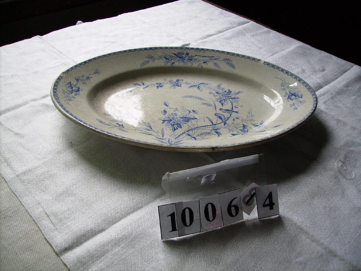 Flintporslin fån Gustavsberg med blad dekor. Skador i glasyr och sprickor.
En djup, två flata, ett uppläggingsfat djup ovalt, ett uppläggningsfat.
Märkta med Gustavsberg, Göteborg.