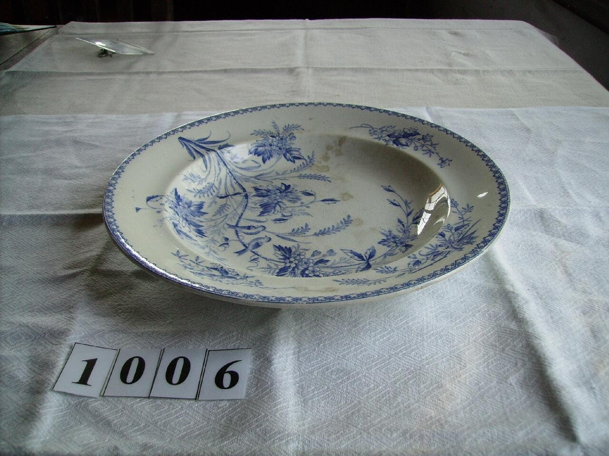 Flintporslin fån Gustavsberg med blad dekor. Skador i glasyr och sprickor.
En djup, två flata, ett uppläggingsfat djup ovalt, ett uppläggningsfat.
Märkta med Gustavsberg, Göteborg.
