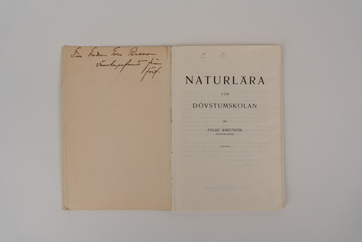 En skolbok med beige omslag, innehållande både text och illustrationer.