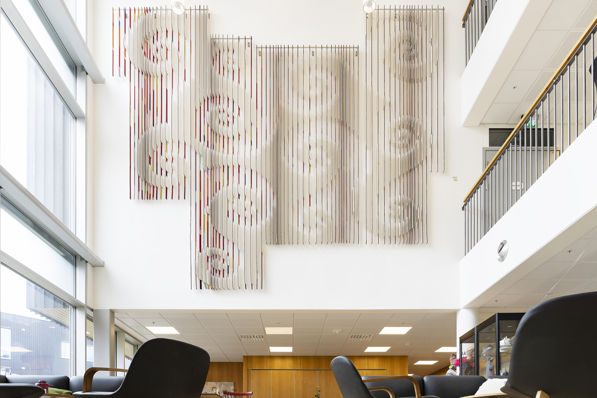 Store, overlappende spiraler som er visuelt knyttet sammen og danner et større, sammenhengende mønster over de forskjellige lamellpanelene.
