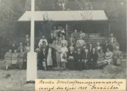 Fotografi gruppporträtt. Text: "Arvika dövstumförenings sommarstuga invigd den 8 juli 1939 "Granliden".
