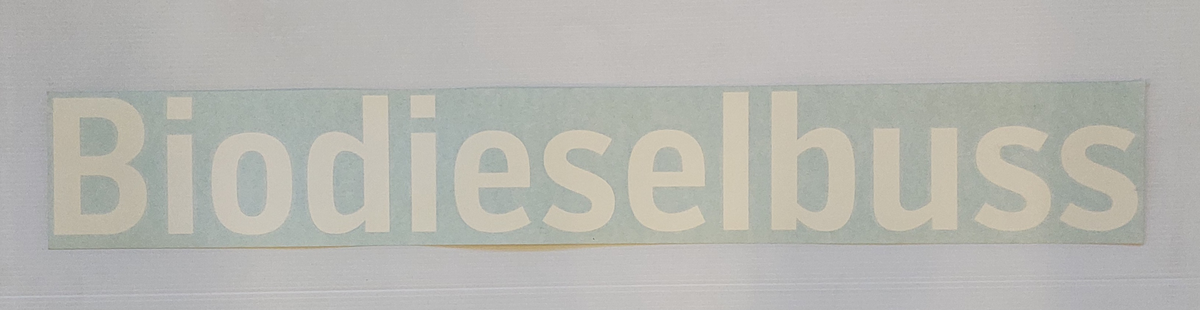 Klisterdekal med texten Biodieselbuss, för montage på bussens utsida.