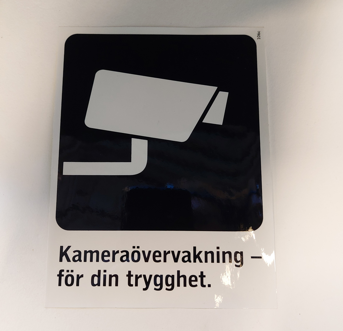 Klisterdekal med piktogram av en kamera samt text om kameraövervakning.