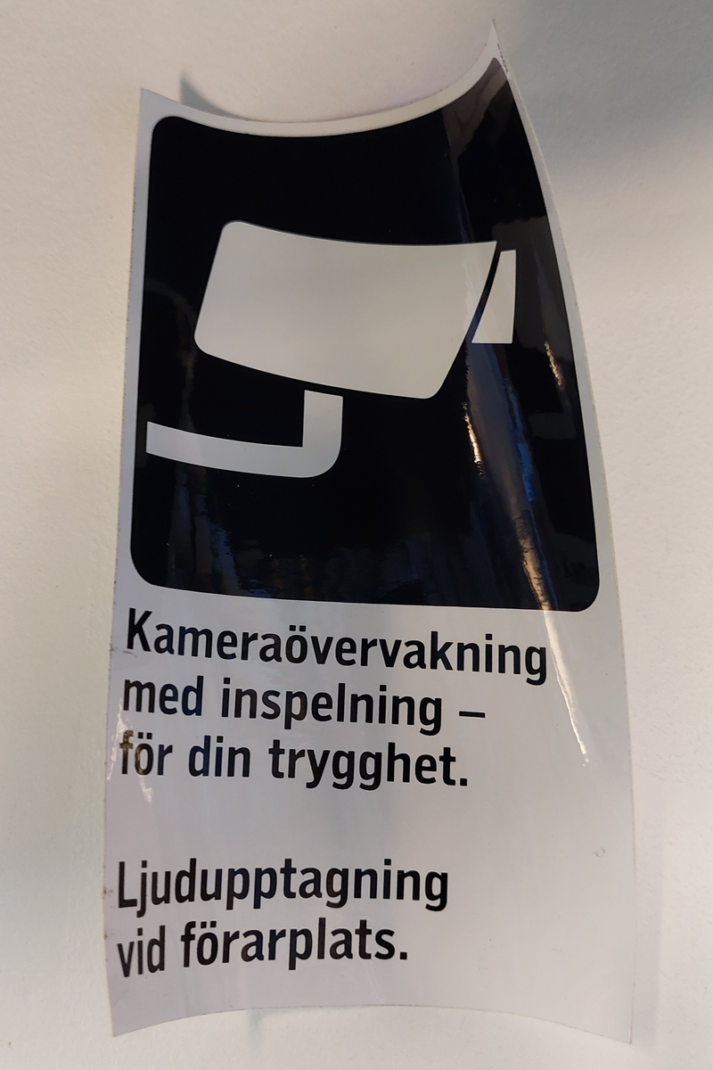 Klisterdekal med piktogram av en kamera samt text om kameraövervakning.