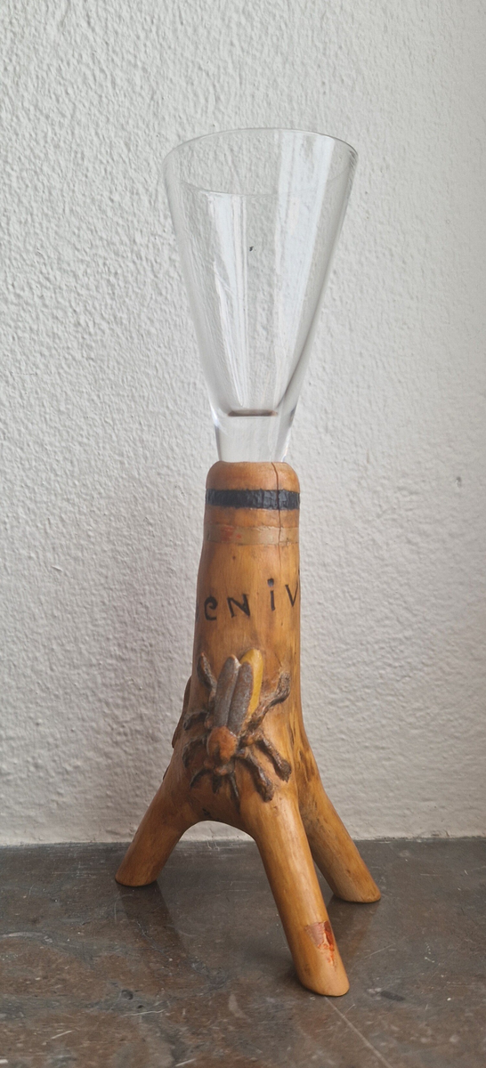 Snapsglas med snidad fot. Motiv: en geting och en groda. Text: "Armen i vinkel". Signerad BF -54. (1954.) Bernhard Frisendal. Gåva av Ing Marie Hedebrand, Sundsvall. 
