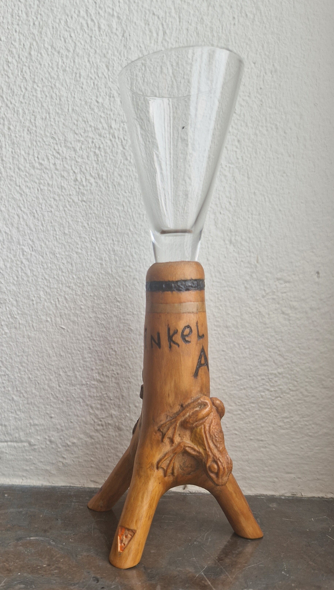 Snapsglas med snidad fot. Motiv: en geting och en groda. Text: "Armen i vinkel". Signerad BF -54. (1954.) Bernhard Frisendal. Gåva av Ing Marie Hedebrand, Sundsvall. 