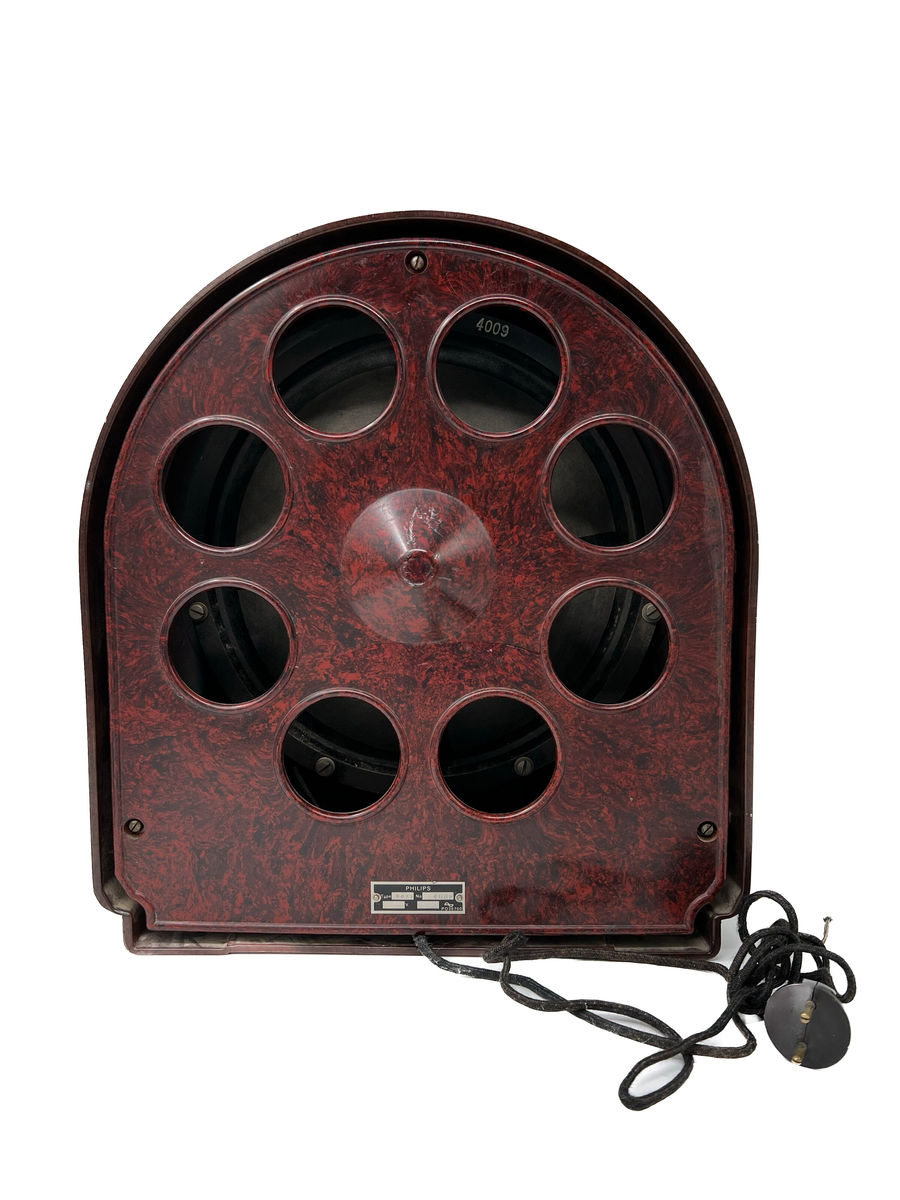 Radioapparat med högtalare.
Högtalaren är tillverkad av Philips ca 1930. Modellnummer 2032. Bakelit. 
Radion i trä, medföljande kopplingschema finns inuti radion. Radion tillverkad av Edins instrument och reparationsverkstad (Edins radio) i Härnösand. 