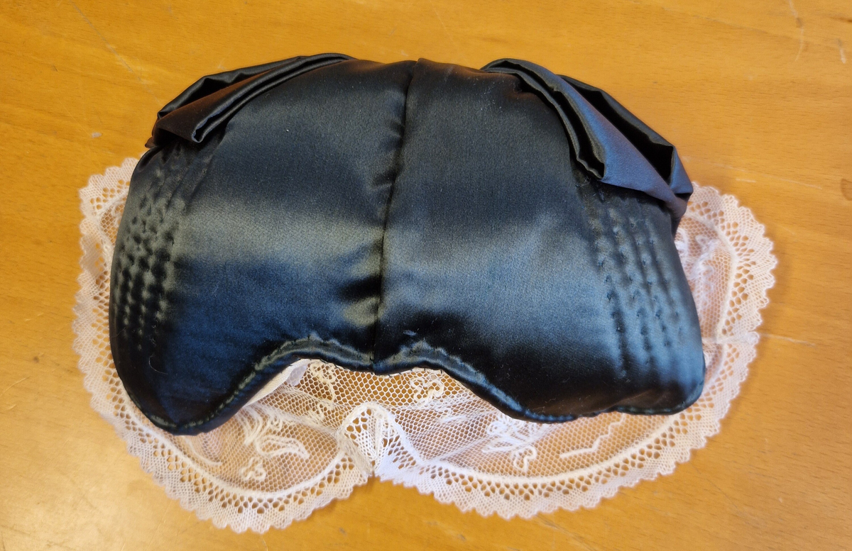 Folkdräkt från Ådals-Liden. Livkjol, överdel, förkläde, halskläde, kjolsäck, mössa, strumpbyxor och skor. Halsklädet, metallspännet på kjolsäcken, strumpbyxorna och skorna är inköpta. Skorna med etikett inuti: "Britta från Wiskania". Svensk kvalitet. Storlek 4½. Kjolsäcken är märkt med initialerna I F, (Ing-Marie Frisendal) och 1954. Gåva av Ing-Marie Hedebrand, Sundsvall. Tillverkad av Ing-Maries syster, Margareta Frisendal.
Anm: Folkdräkten från Ådals-Liden, en del av Ångermanland, har livkjol av helylle med empireskärning, ett vitt linneförkläde (modell södra dräkten) och en bindmössa i rött eller grönt, inspirerad av södra dräkten. Överdelen är en linnesärk med hålsöm vid ärmsluten och en utåtvikt fåll vid halsringningen. 
En kjolsäck, som tillhör dräkten, är gjord av blått ylletyg med applikationer i rött och gult, med ett centralt placerat hjärta och andra dekorativa former. 
Ådals-Lidens folkdräkt är en del av de två typerna av ångermanländska folkdräkter, den södra och den norra, som presenterades av Ångermanlands hemslöjdsförening år 1922. 
Källa: https://www.draktnyckel.se/adalsliden/