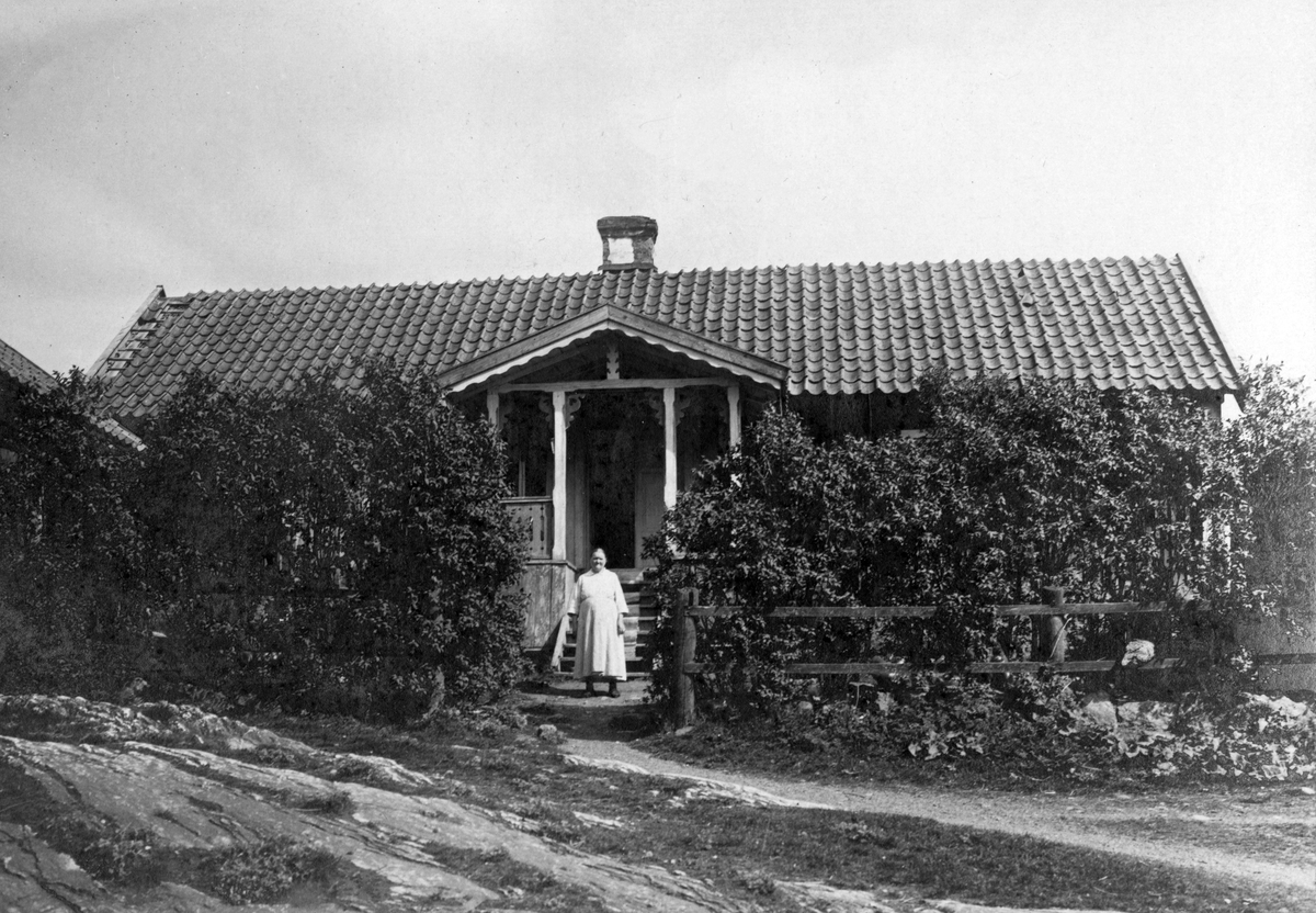 Mellangården i Jursta. Wilhelmina Andersson står framför trappan.

Sommar.

Personer på bilden:
Wilhelmina Andersson f. Karlsson, född 1866-02-06 i Litseläng, Ösmo, död 1933-10-16 i Drakboda, Ösmo.