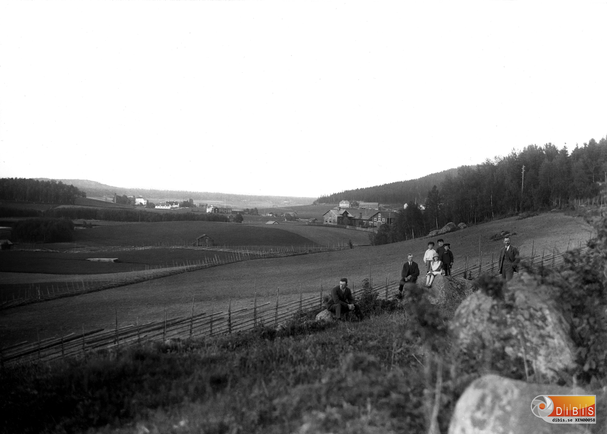 Vy från Polberg, Fr,v: ser man Höjen, Per-Hans, Jon-Pers ocb Brattåker.
Personerna i förgrunden fr,v: Jonas Lönn, Nils Eriksson, Västergården,
Gustav Eriksson, Västergården, (i vit skjorta), Sune Lönn (Jonas  son),
Gustav Bratt, Östergården, Anna Eriksson, Västergården och Johan Persson,
¨Lust-Johan¨ från Berga.