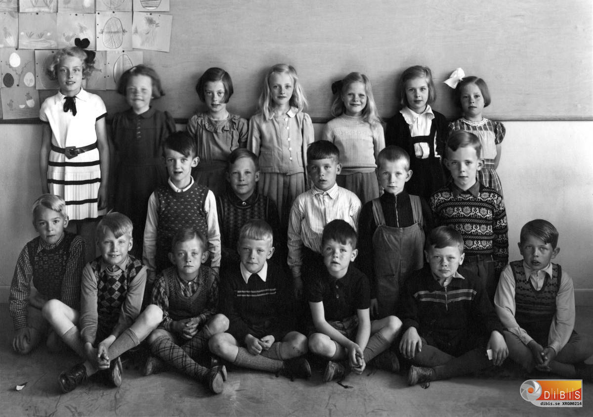Klass 1 eller möjligen 2 på Centralskolan (i dag 2013 Norrtullsskolan) i Söderhamn.
Ett försök att namnge eleverna blir enligt följande:
Bakre raden: Birgitta Persson, Marianne Gullström, ?, Eva Grandien, Anne-Kristine Bäckman, ?, Maj Olsson.
Mellanraden: Sten Hörnfeldt, Rolf Sjöström, ?, Bernt Karlsson, ?.
Den låga raden: Rune Gustafsson, Curt Bäckström, Nils Gunnar Jonsson, Sven-Gunnar Erberth, Lars Björin, Stig Jonsson, Lennart Borg.
Lärarinnan som inte är med på bilden hette Hanna Larsson