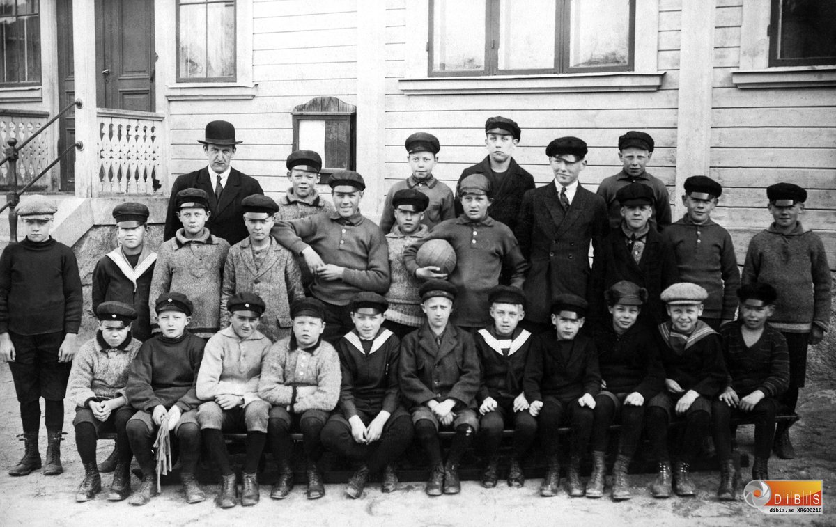 Detta är en skolklass i Söderhamn i början av 1920-talet. Bredvid läraren står Elver Gustafsson (1915-2005).