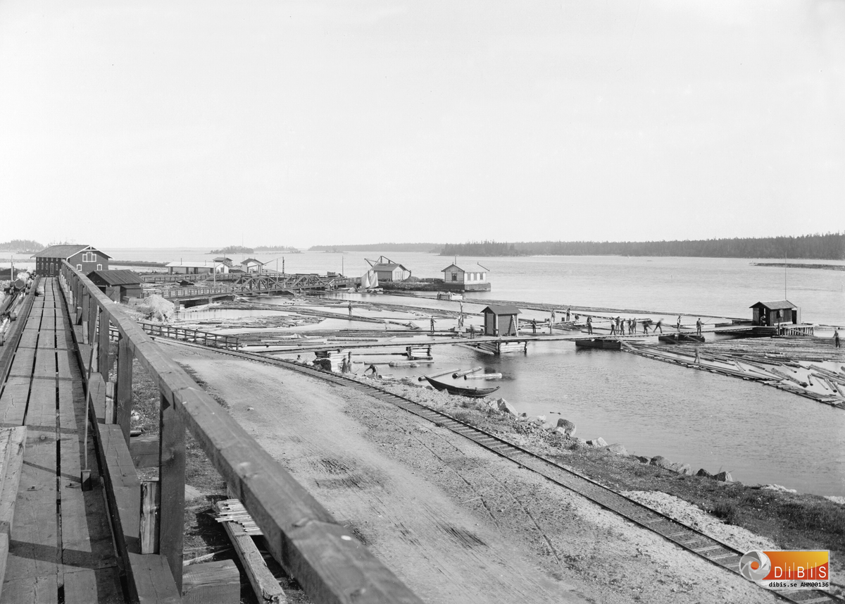Från vänster; Strandmagsinet kajen (i bakgrunden), Ljusne med timmerhantering till höger vid Ljusnans mynning..