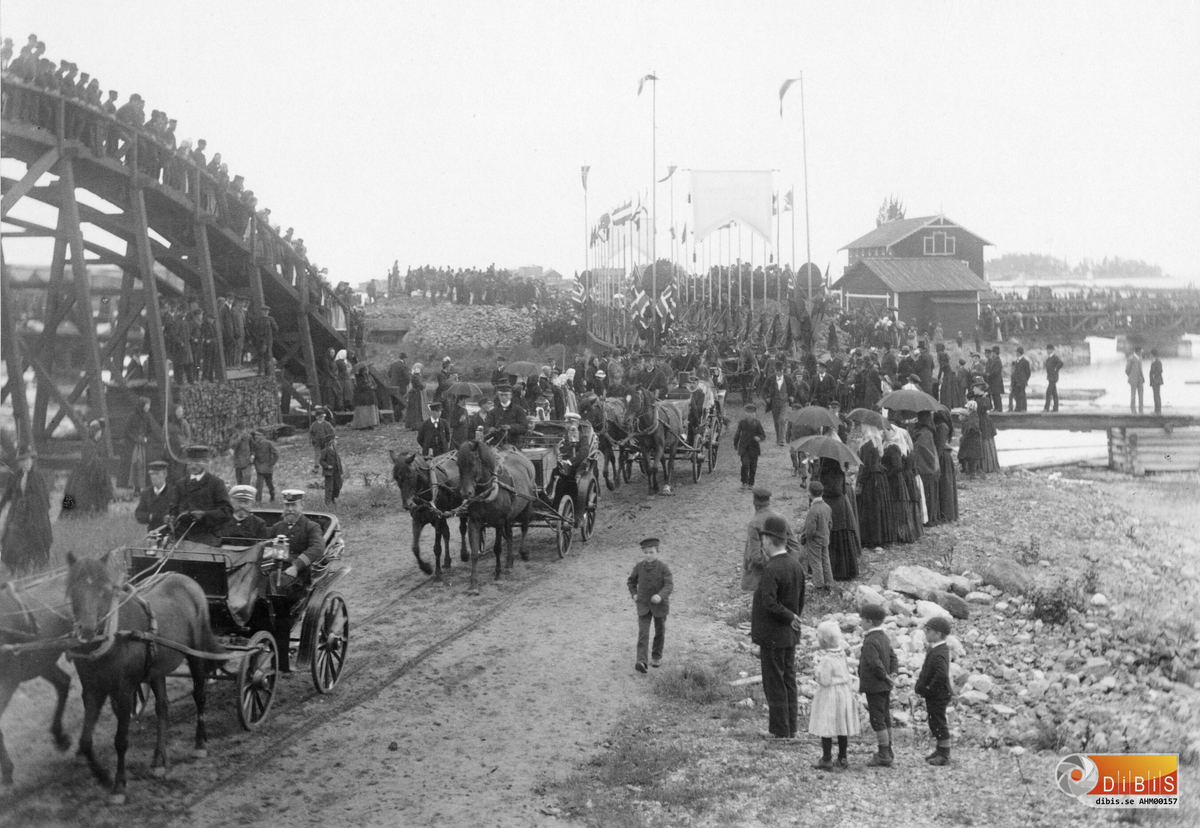 Kung Oscar II kommer till Ljusne den 20 augusti 1890, på sitt fartyg Drott.
På bilden ses den kungliga kortegen passera timmerbanan, som är till vänster, på väg till besöken i de olika verkstäderna.

Utdrag ur Söderhamns Tidning den 23/8 1890:
"Efter promenaden över bron väntade ekipagen, som skjutsade Konungen med sitt följe, till de olika verkstäderna som besöktes. Vägen kantades av flerdubbla led med människor."
"Konungen företog under dagen besök i de flesta av Ljusnes verkstäder.  Kättingsmedjan, Mekaniska Verkstaden och Gjuteriet, Sågen, Masugnen och Valsverket fick alla besök av konungen med sitt följe."