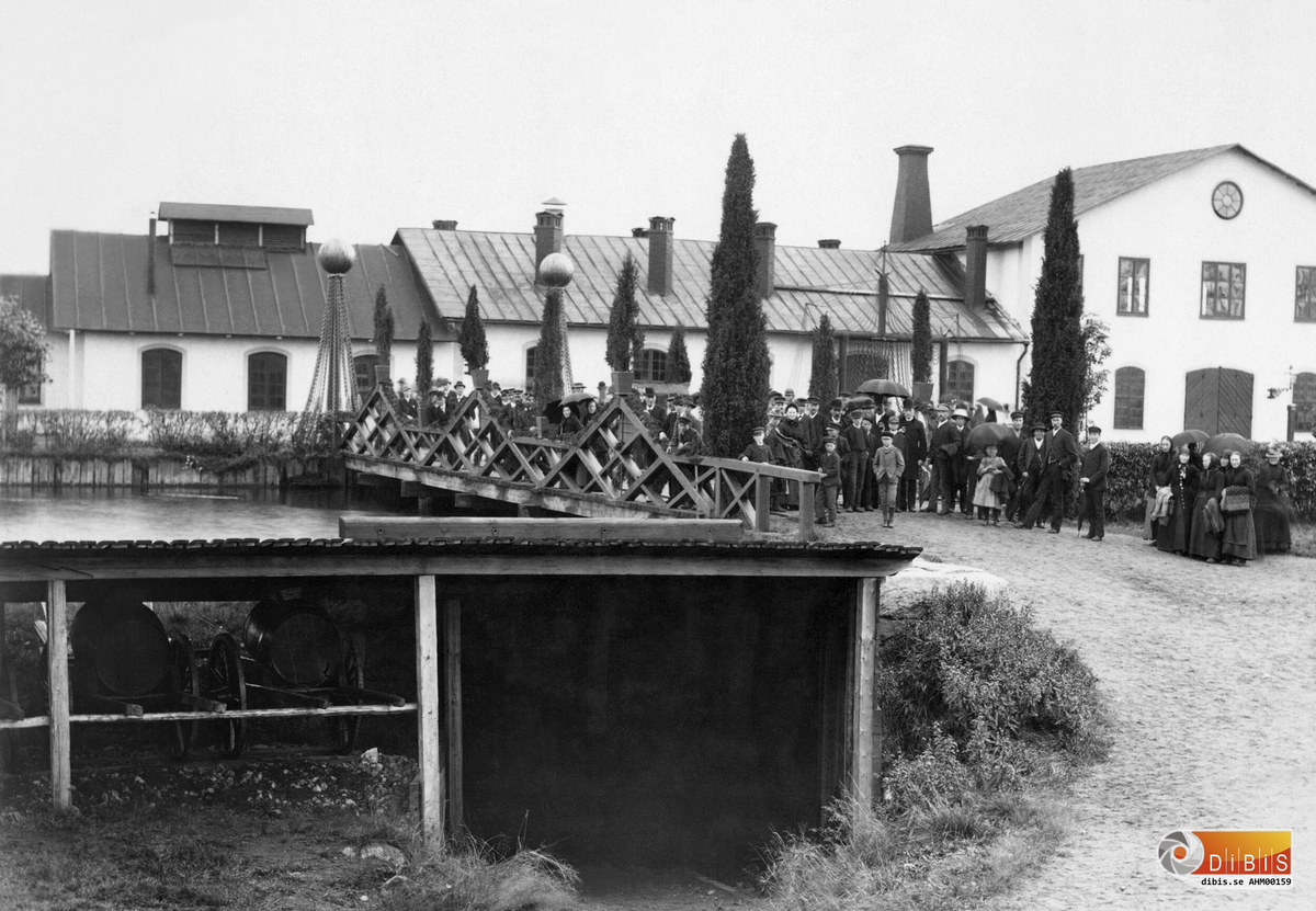 Ljusnebor väntar på konung Oscar II på bron över kanalen till Kättingfabriken i Ljusne.

Utdrag ur Söderhamns Tidning den 23/8 1890:
KUNGABESÖKET ONSDAGEN DEN 20 AUGUSTI 1890 I LJUSNE
Vid besöket i Kättingsmedjan, där konungen med synbart intresse betraktade hur de bastanta järnstyckena under smedernas flinka hammarslag ombildades till kättinglänkar.