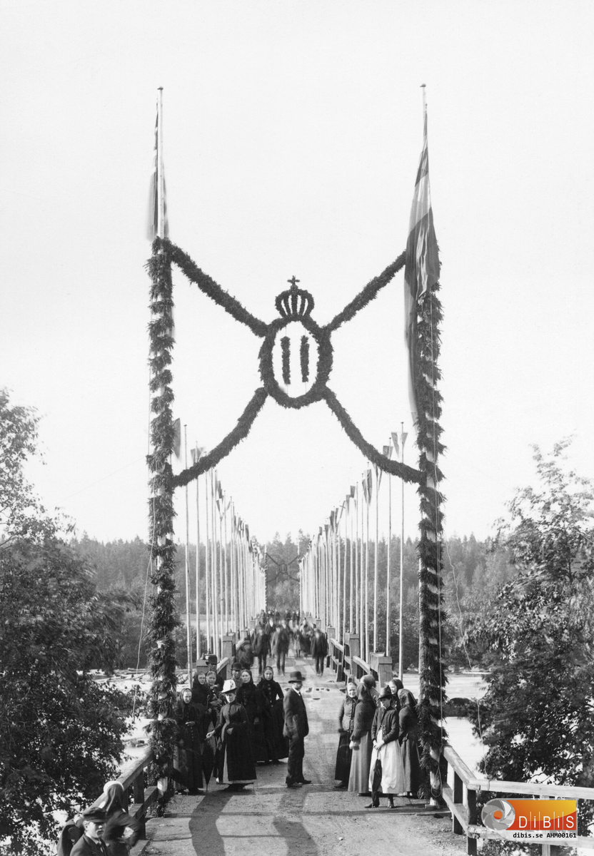 Väntande Ljusnebor på träbron i Ljusne som är dekorerad inför Oscar II:s besök.

Utdrag ur Söderhamns Tidning den 23/8 1890:
KUNGABESÖKET ONSDAGEN DEN 20 AUGUSTI 1890 I LJUSNE
Konungen besökte hyttan vid Ljusne Järnverk. Vägen dit gick över den flaggprydda och med girlanger smakfullt dekorerade masugnsbron, även här kantades bron av flerdubbla led med människor.
Masugnen och Valsverket stod därefter i tur för besök. I Valsverket dröjde Konungen sig kvar särdeles länge och följde med livligt intresse den procedur varigenom de glödande, oformliga järnstyckena under ilande fart mellan valsarna omdanades till fina smidiga järnstänger.