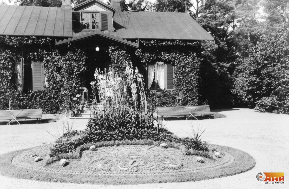 Trädgårdsrabatt framför lilla chefsvillan.
Den byggdes på 1860-talet  i schweizerstil av Wilhelm Kempe. Det fanns även en större villa mitt emot den som flyttades några hudratals meter uppströms Ljusnan som där blev prästgård för att ge plats åt  von Hallwyls chefsvilla.
Chefsvillan finns på bild AHM 00197.