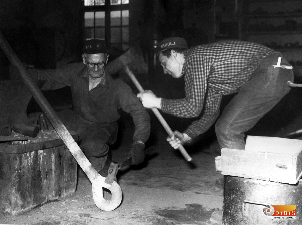 Handsmeden Stig Goode med sätthammaren och släggdrängen Bernt Söderholm . Lite kul att se Bernt som släggdräng, han talade så mycket om det för oss yngre när vi jobbade på "smea" på 80-talet! Bernts öknamn är JONE!
